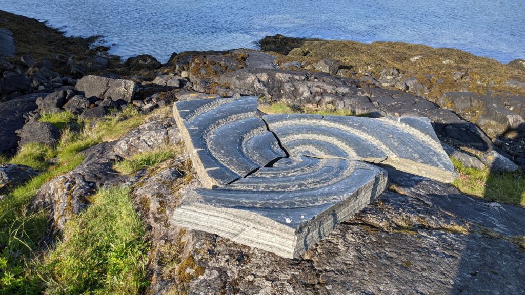 Photograph of a sculpture of an spiral broken into three parts, from Vega Island in Norway